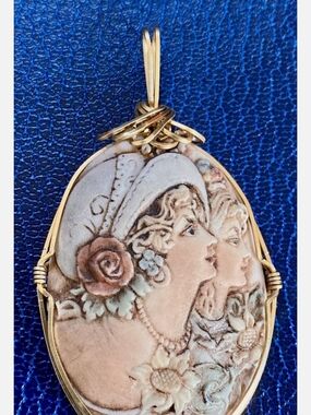 This JHK bisque porcelain cameo pendant features a hand-painted double portrait